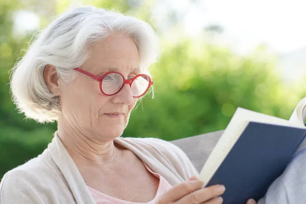 Ανώτερη Γυναίκα Κόκκινα Γυαλιά Διαβάζοντας Βιβλίο Έξω — Φωτογραφία Αρχείου