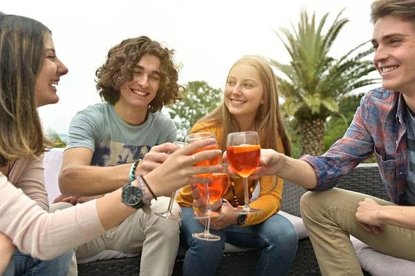 Group of friends having a drink together, celebrating end of school year