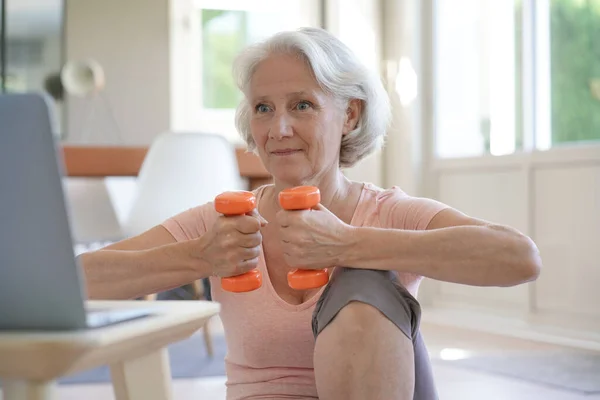 Üst Düzey Kadın Sanal Sınıfla Spor Yapıyor Elinde Dambıllar Var — Stok fotoğraf