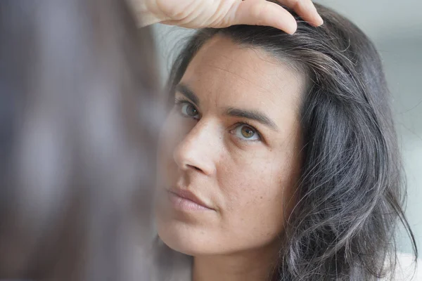 Mulher Meia Idade Verificando Raízes Cabelo Frente Espelho — Fotografia de Stock