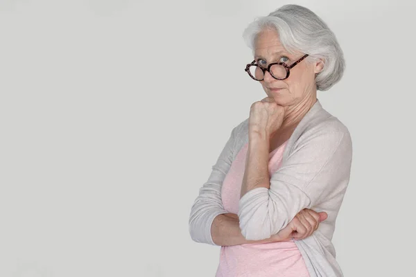 戴着眼镜站在白底 孤立无援的老年妇女的画像 — 图库照片