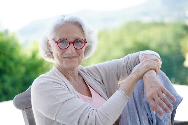 Porträtt Äldre Kvinna Med Röda Glasögon Avkopplande Fåtölj Utanför — Stockfoto