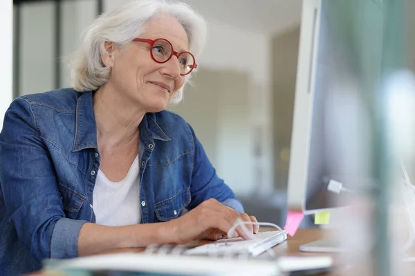 Senior Kvinde Der Arbejder Stationær Computer Derhjemme - Stock-foto