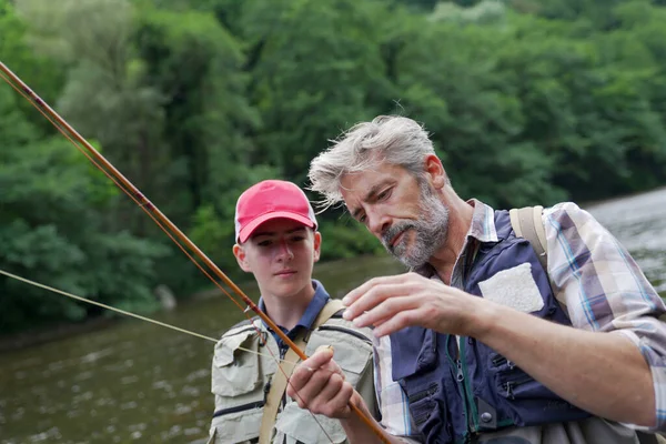 父と息子は夏に澄んだ水のある美しい川で釣りをする — ストック写真