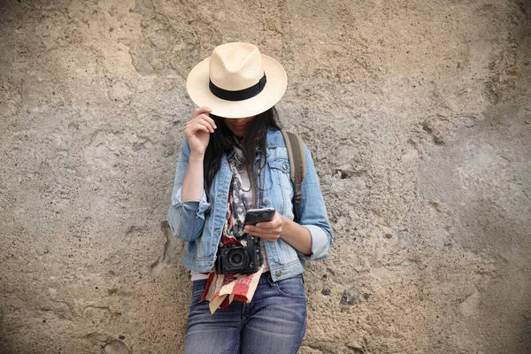 Mulher Vestindo Jeans Azul Chapéu Contra Parede Usando Smartphone — Fotografia de Stock