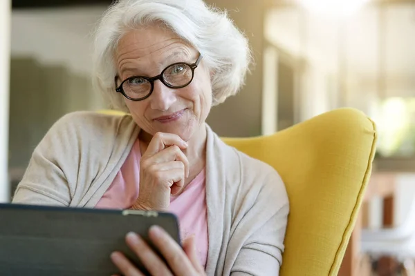 Старша Жінка Розслабляється Кріслі Використовує Цифровий Планшет Ліцензійні Стокові Фото