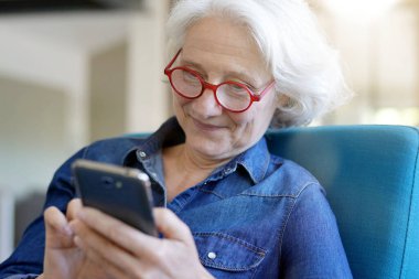 Akıllı telefon kullanan yaşlı bir kadının portresi