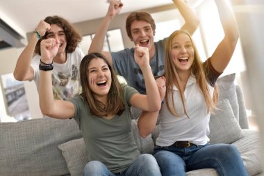 Bir grup arkadaş TV 'de maç izlerken neşeleniyor