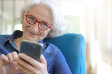 Akıllı telefon kullanan yaşlı bir kadının portresi