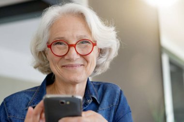 Akıllı telefon kullanan yaşlı bir kadının portresi