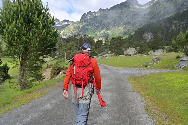 夏には高い山の川に赤いバックパックと赤いジャケットの釣りを持つフライフィッシング — ストック写真