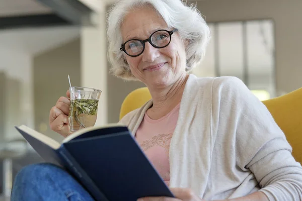 Старша Жінка Розслабляється Кріслі Читає Книгу — стокове фото