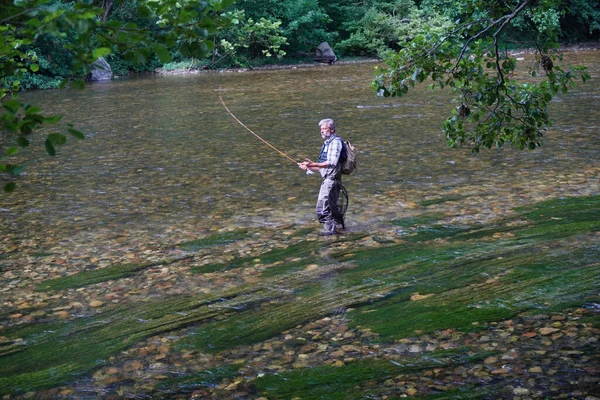 男は澄んだ水と美しい川で夏に釣りを飛ぶ — ストック写真