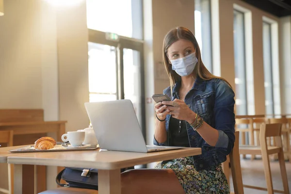 Mujer Joven Sentada Cafetería Trabajando Ordenador Portátil Con Máscara Facial —  Fotos de Stock