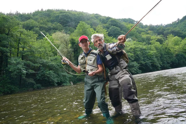父と息子は夏に澄んだ水のある美しい川で釣りをする — ストック写真