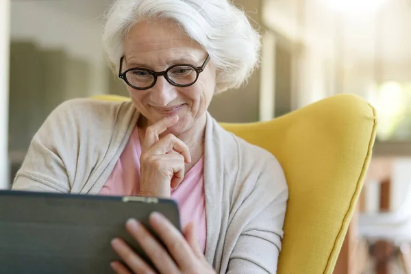 Senior Vrouw Ontspannen Fauteuil Met Behulp Van Digitale Tablet — Stockfoto
