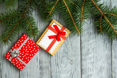 iki Noel hediyeleri yeşil ağaç dalları gri bir vintage ahşap zemin üzerine şenlikli bir kutu içinde