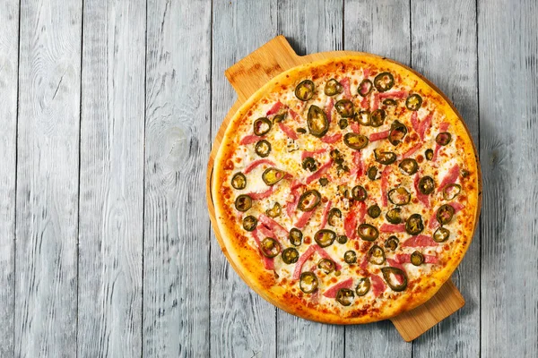 Üstten görünüm akut lezzetli İtalyan pizza jalapeno gri ahşap zemin üzerine adet