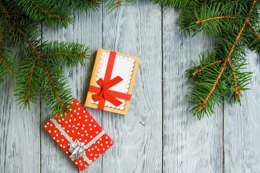 iki şenlikli Noel kutu yeşil ağaç dalları gri bir vintage ahşap zemin üzerine