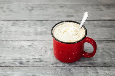 kırmızı ahşap zemin üzerine krema ile sıcak içecek fincan. Kopya alanı