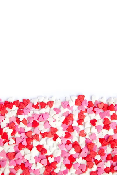 white background and pink red sweet sprinkling hearts poured horizontally background