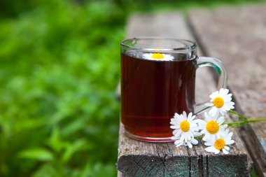 bir demet papatya çiçeği ve bir ahşap eski arka plan bahçe bitki çayı. Rustik natürmort