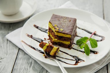 Çikolatalı üç kat kek ve bir kafede beyaz tabakta miny parça