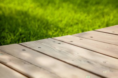 Bulanık yaz yeşili arka plan ile görüntü üzerinde diyagonal ahşap masa