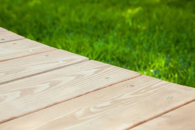 Bulanık yaz yeşili arka plan ile görüntü üzerinde diyagonal ahşap masa