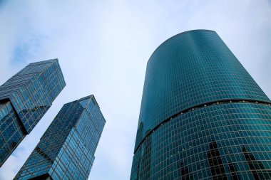 Mavi gökyüzüne karşı modern cam gökdelenlerin üst görünümü.