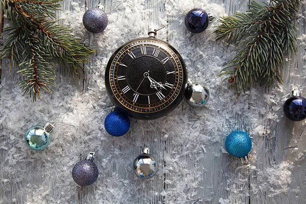 Розкидані різдвяні іграшки і годинник на сірому сніжному дерев'яному столі. Вид зверху. Різдвяний фон . — стокове фото