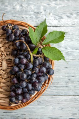 Yuvarlak bir tepside olgun koyu üzümlerden oluşan bir küme. Üst görünüm ve kopyalama alanı