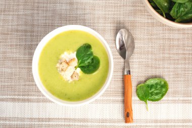 Beyaz kasede ıspanak yapraklı yeşil kremalı çorba. Tepeden manzara. Sağlıklı bir yaşam için lezzetli ıspanak çorbası.