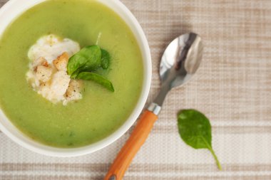 Beyaz kasede ıspanak yapraklı yeşil kremalı çorba. Tepeden manzara. Sağlıklı bir yaşam için lezzetli ıspanak çorbası.