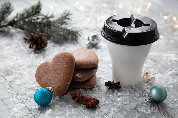 Kielich gorącego kakao z piankami i bożonarodzeniowym piernikiem w postaci serca na śnieżnym drewnianym tle. — Zdjęcie stockowe