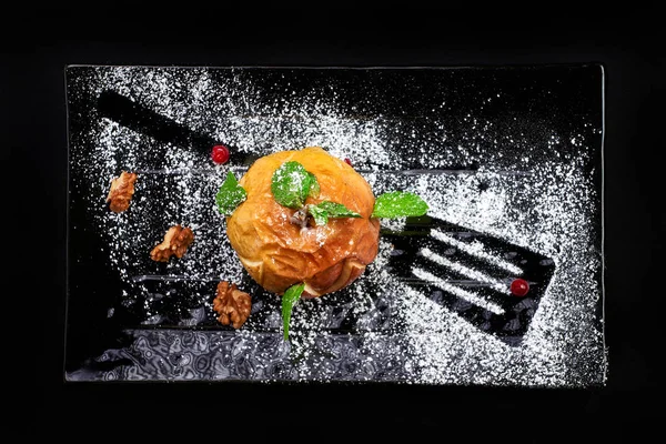 Maçã assada gourmet. Sobremesa de outono em fundo preto com sug — Fotografia de Stock
