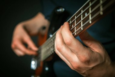 Bas gitar ile pratik rock gitaristi closeup.