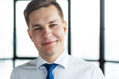 Kameraya bakarak kendine güvenen genç iş adamı portresi.