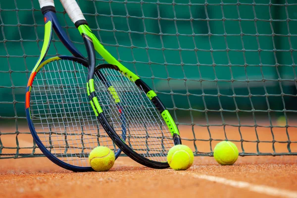 Теннисные ракетки и мячи прислонились к сетке . — стоковое фото