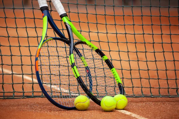 Tennis rackets and balls leaned against the net. — Stock Photo, Image