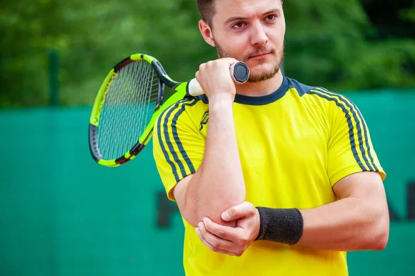 Joueur de tennis masculin tenant son coude blessé . — Photo
