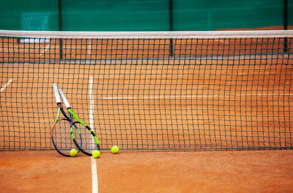 Tennis rackets and balls leaned against the net. Stock Picture