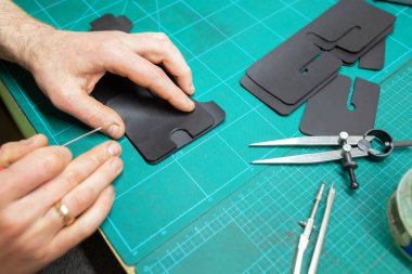 Deri ustası deriyle çalışıyor. Cüzdan yapıyorum..