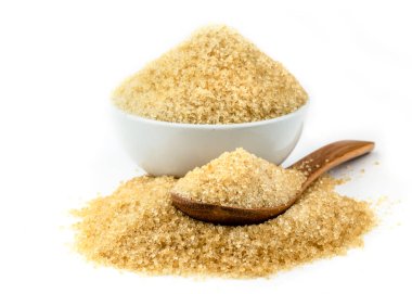 beyaz zemin üzerine tahta kaşıkla kahverengi şeker kamışı.