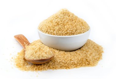 beyaz zemin üzerine tahta kaşıkla kahverengi şeker kamışı.