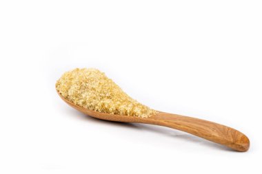 beyaz zemin üzerine tahta kaşıkla kahverengi şeker kamışı.