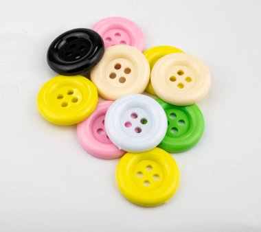 Beyaz arkaplanda izole edilmiş renkli dikiş düğmeleri.