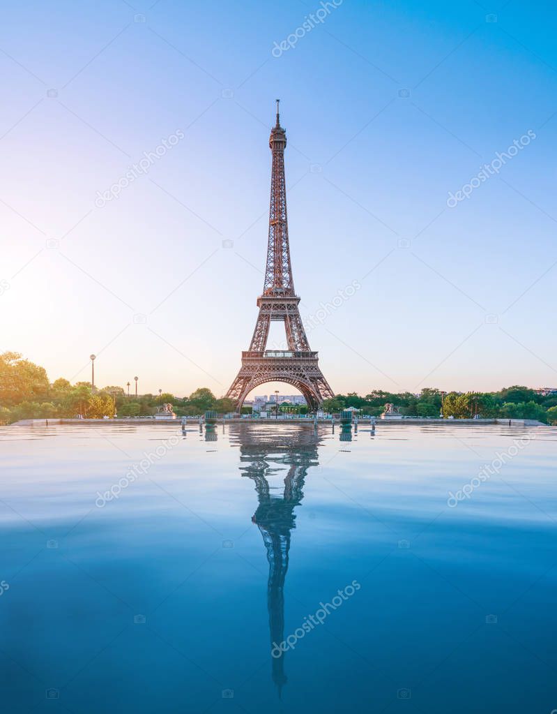 the famous paris eiffel tower on a sunny day with some morning sunshine reflects in blue water
