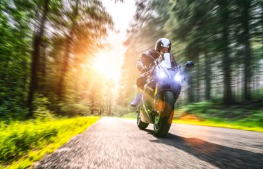 Orman yolunda motosiklet sürerken. Motosiklet turunda boş bir yolda araba sürerken eğleniyorum. bireysel metniniz için kopyalama alanı.