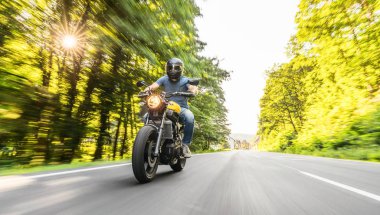 Orman yolunda modern motorsiklet yarışları. Motosiklet turunda boş bir yolda araba sürerken eğleniyorum. bireysel metniniz için kopyalama alanı.